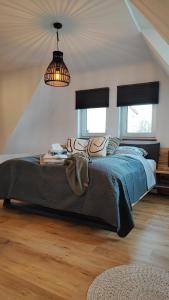 una camera da letto con un letto con un piumone blu e due finestre di Ferienhaus Polly a Taucha