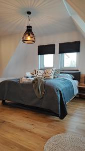 a bedroom with a bed with a blue comforter and two windows at Ferienhaus Polly in Taucha