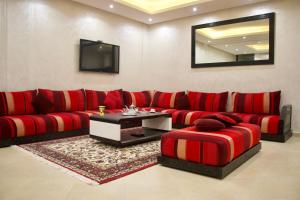 a living room with a red couch and a tv at Magnifique Duplex à Marrakech in Marrakech