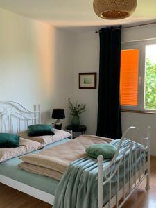 - une chambre avec 2 lits et une fenêtre dans l'établissement Apartament Blumenblick, à Rielasingen-Worblingen