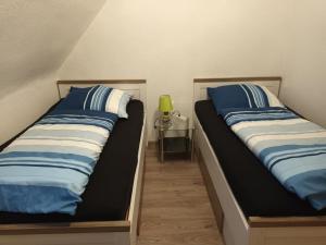 duas camas sentadas uma ao lado da outra num quarto em Ferienwohnung Wiesengrund em Hahnstätten