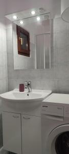 a bathroom with a sink and a washing machine at Sunset Apartments in Slano