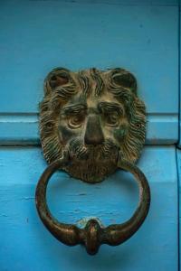 una puerta de bronce de una cabeza de león en una puerta azul en Guesthouse Lion, en Split