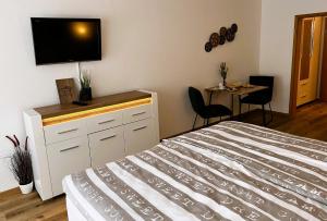 a bedroom with a bed and a flat screen tv at Ferienwohnung Traumwerk Titisee in Titisee-Neustadt