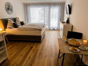 ein Schlafzimmer mit einem Bett und einem Tisch mit Essen darauf in der Unterkunft Ferienwohnung Traumwerk Titisee in Titisee-Neustadt