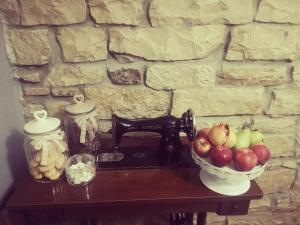 un tavolo con una ciotola di mele e una macchina da cucire di Gesualdo da Venosa a Venosa