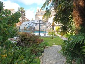 invernadero en un jardín con piscina en Le Manoir de Kérofil ** Gîte et chambres d'hôtes **, 