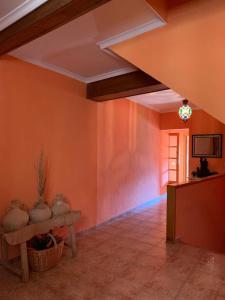 Habitación con paredes de color naranja, mesa y jarrones. en CA MATI, en Serón