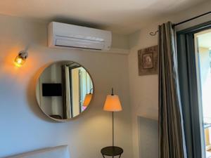 una camera con specchio e condizionatore d'aria di appartement cosy avec climatisation réversible GOLF DE SAUMANE a Saumane-de-Vaucluse