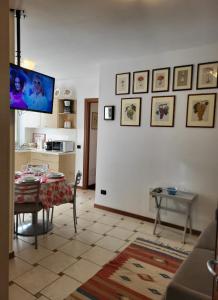 - un salon avec une table et une télévision murale dans l'établissement Residence Belvedere Apartment Bolvedro, à Tremezzo
