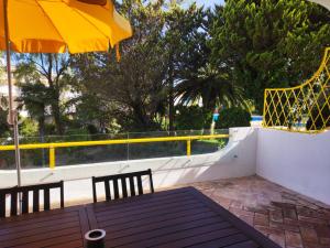 een patio met een tafel en een parasol bij Golden Beach Vilamoura in Quarteira