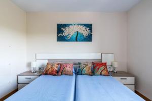 a bedroom with a blue bed with colorful pillows at Miraflores Luxury Suites in Seville