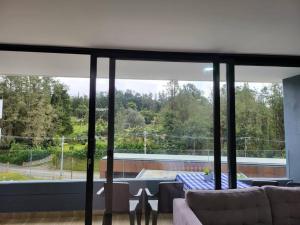 a living room with a couch and a large window at Entire Apartment in El Retiro in El Retiro