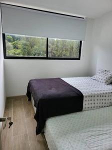 a bedroom with two beds and a large window at Entire Apartment in El Retiro in El Retiro