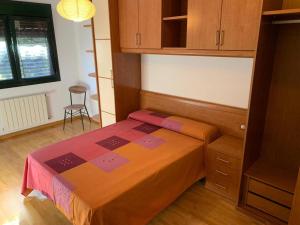 a small bedroom with a bed and a chair at Apartamento Roces in Gijón