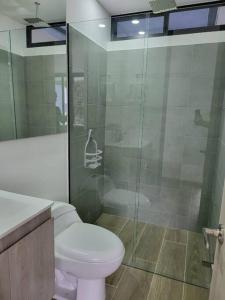 a bathroom with a toilet and a glass shower at Entire Apartment in El Retiro in El Retiro