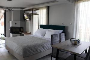 a bedroom with a large bed and a table at OLYMPUS Paradise 4 in Skotina