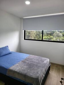 a bedroom with a bed and a large window at Entire Apartment in El Retiro in El Retiro
