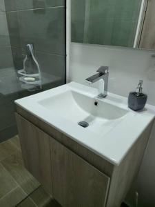 a bathroom with a white sink and a mirror at Entire Apartment in El Retiro in El Retiro