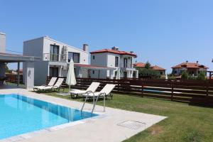 a villa with a swimming pool in front of a house at OLYMPUS Paradise 4 in Skotina