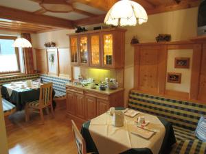 a dining room with two tables and a kitchen at Haus Alpenglühn in Schladming