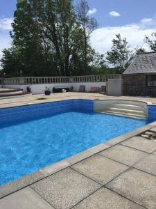 uma piscina com água azul num quintal em The Grooms Quarters em Loughor