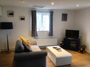 a living room with a couch and a coffee table at The Grooms Quarters in Loughor