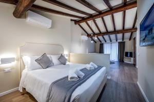 1 dormitorio con 1 cama blanca grande y toallas. en Garibaldi Luxury apartments, en Prato
