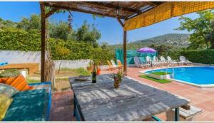 eine Terrasse mit einem Tisch und einem Pool in der Unterkunft Casa Rural la Joya in Iznájar