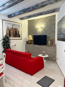 un soggiorno con divano rosso e TV di casa vacanza serena a Palazzago