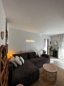 een woonkamer met een bruine bank en een tafel bij Bel appartement dans le centre ville de Cavalaire in Cavalaire-sur-Mer