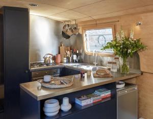 a kitchen with a sink and a counter with dishes at Boutique Barges in London