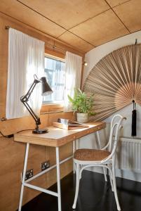 einen Schreibtisch mit einer Lampe und einem Stuhl in einem Zimmer in der Unterkunft Boutique Barges in London