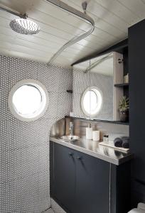 baño con lavabo y 2 ventanas en Boutique Barges, en Londres