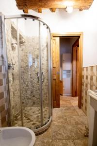 bagno con doccia in vetro e lavandino di La Casetta Nel Borgo a Castelnuovo di Val di Cecina
