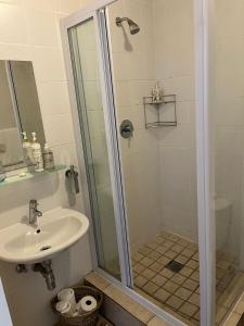 a bathroom with a shower and a sink at Beachside Bliss Strand in Strand