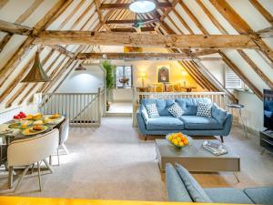 a living room with a blue couch and a table at Haberdashers Loft in Bungay