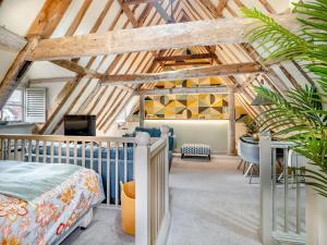 ein Schlafzimmer mit einem Bett im Dachgeschoss in der Unterkunft Haberdashers Loft in Bungay