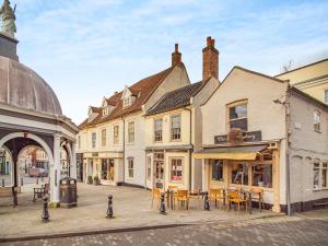 a group of buildings on a street with tables and chairs at Haberdashers Loft in Bungay