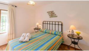 a bedroom with a bed with flip flops on it at Casa Rural la Joya in Iznájar +10 photos