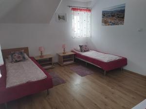 Cette chambre comprend 2 lits et une fenêtre. dans l'établissement Jaskółka, à Lądek-Zdrój