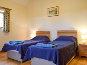 two beds in a room with blue sheets on them at Dragonfly - Uk42521 in Aldwincle Saint Peter