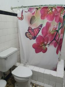 a butterfly shower curtain in a bathroom with a toilet at Casa piedra cartagena in Cartagena