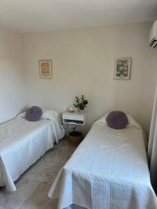 two beds in a room with white walls at Duplex Lisandro de la Torre in San Rafael