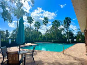 a swimming pool with a table and chairs and palm trees at A Cozy Home Away From Home in Riverview