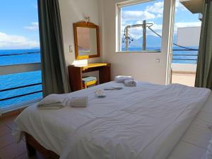 a bedroom with a bed with a view of the ocean at 9 Muses Apartments in Agios Nikolaos