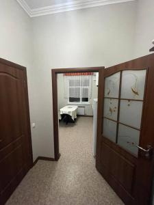 um corredor com uma porta que leva a uma sala de estar em Mondial apartments em Shymkent