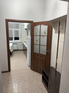 a room with a kitchen with a door and a refrigerator at Mondial apartments in Shymkent