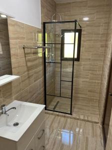 a bathroom with a glass shower and a sink at CAMERE de INCHIRIAT CRIS&DIA in Eforie Sud