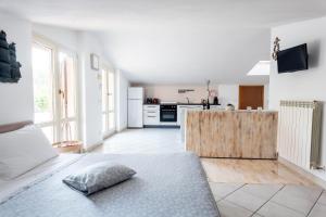 una camera bianca con letto e cucina di MARCHE FULL EXPERIENCE-Apartments a Porto SantʼElpidio